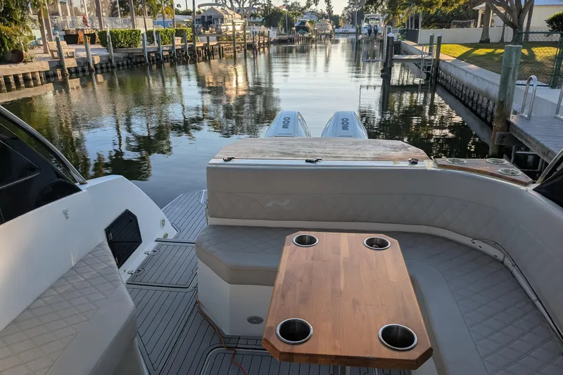 Mbvip Yacht Photos Pics 2023 NX Boats 340 Sport Coupe interior with wooden table and waterfront view.