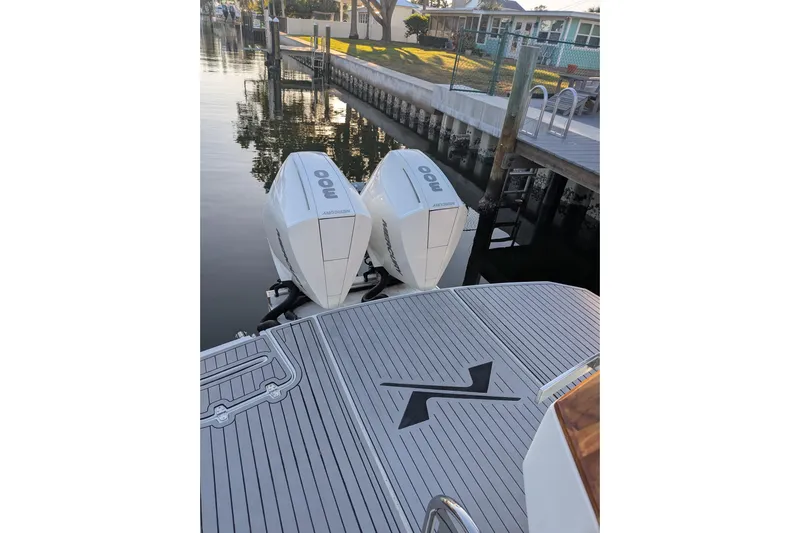 Mbvip Yacht Photos Pics 2023 NX Boats 340 Sport Coupe with twin outboard engines docked by a canal.