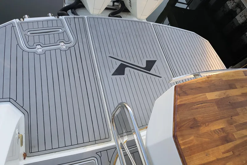 Mbvip Yacht Photos Pics 2023 NX Boats 340 Sport Coupe deck with wood and gray detailing.