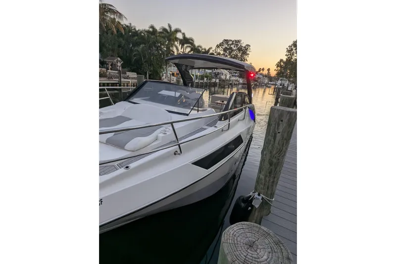 Mbvip Yacht Photos Pics 2023 NX Boats 340 Sport Coupe docked at sunset, sleek design.