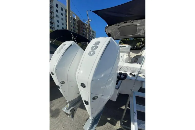 Mbvip Yacht Photos Pics 2023 NX Boats 340 Sport Coupe with dual 300 horsepower engines, docked under clear skies.