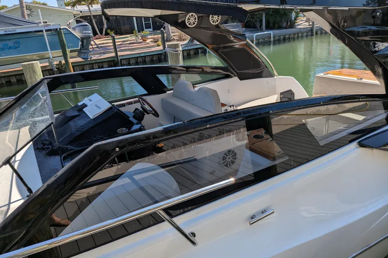 Mbvip Yacht Photos Pics 2023 NX Boats 340 Sport Coupe, sleek design, docked in a marina setting.