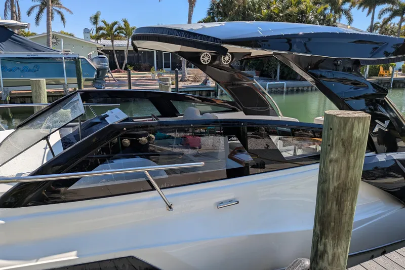 Mbvip Yacht Photos Pics 2023 NX Boats 340 Sport Coupe docked by a waterfront, showcasing sleek design.