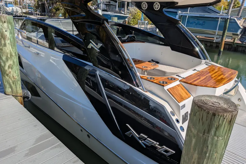 Mbvip Yacht Photos Pics 2023 NX Boats 340 Sport Coupe docked, showcasing sleek design and luxurious wood accents.
