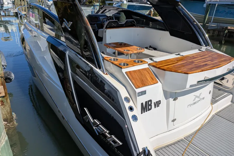 Mbvip Yacht Photos Pics 2023 NX Boats 340 Sport Coupe docked, showcasing sleek design and wooden accents.