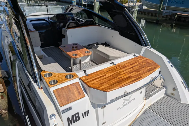 Mbvip Yacht Photos Pics 2023 NX Boats 340 Sport Coupe with elegant wood accents and spacious seating area.