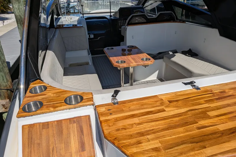 Mbvip Yacht Photos Pics 2023 NX Boats 340 Sport Coupe interior with wood accents and seating area.