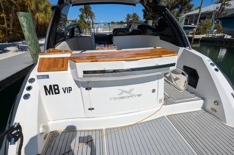 Mbvip Yacht Photos Pics 2023 NX Boats 340 Sport Coupe, rear view, docked, featuring teak accents and sleek design.