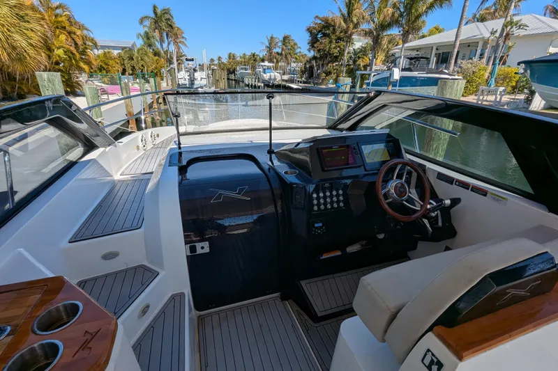 Mbvip Yacht Photos Pics 2023 NX Boats 340 Sport Coupe cockpit with modern controls and luxurious seating.