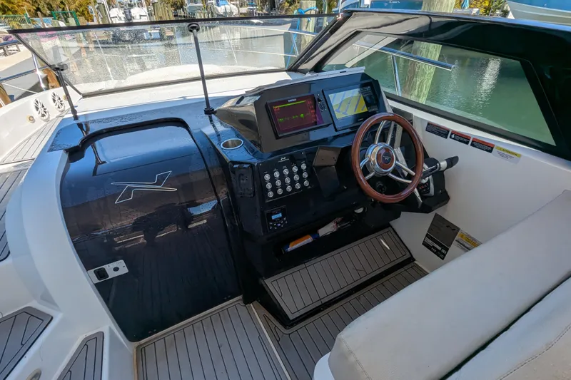 Mbvip Yacht Photos Pics 2023 NX Boats 340 Sport Coupe cockpit with modern controls and steering wheel.