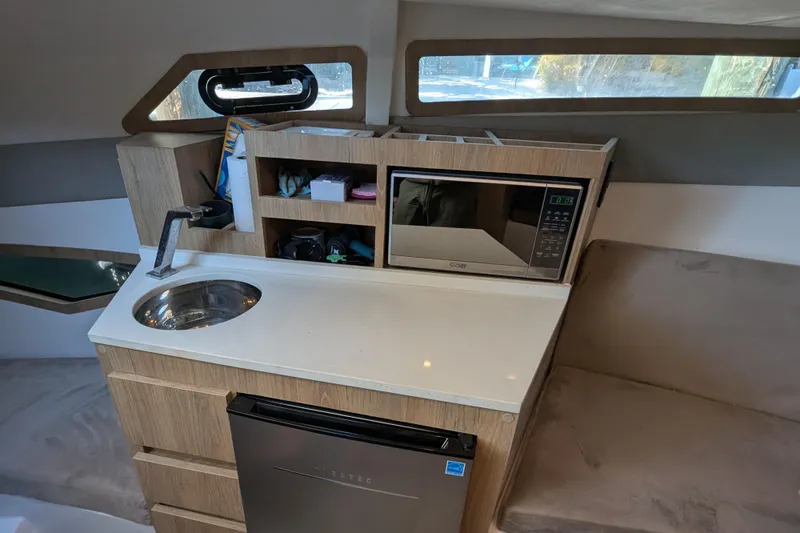 Mbvip Yacht Photos Pics 2023 NX Boats 340 Sport Coupe interior with kitchenette, sink, microwave, and compact fridge.