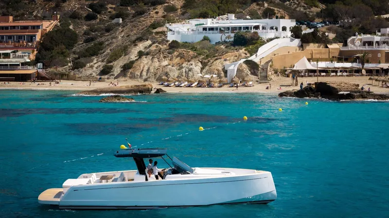 Yaaas Yacht Photos Pics 2024 Pardo Yachts P43 cruising in turquoise waters near a scenic coastal landscape.