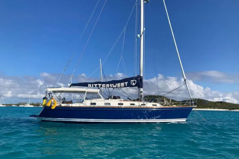 Bittersweet Yacht Photos Pics Sailboat Tartan 4100, 1989 model, named "Bittersweet" on turquoise water under blue sky.