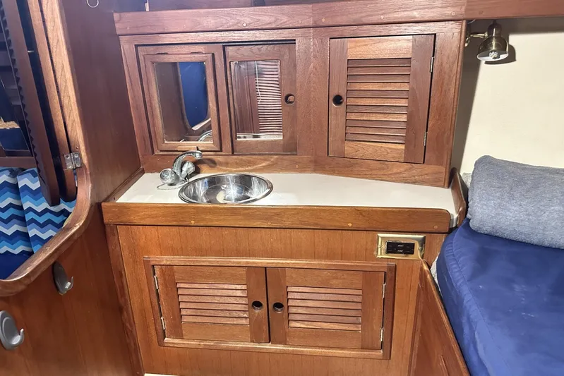 Bittersweet Yacht Photos Pics Wooden interior of 1998 Tartan 4100 sailboat with sink and storage cabinets.