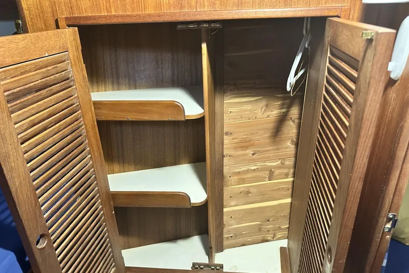 Bittersweet Yacht Photos Pics Wooden cabinet interior with shelves and hangers, Tartan 4100, 1998 model.