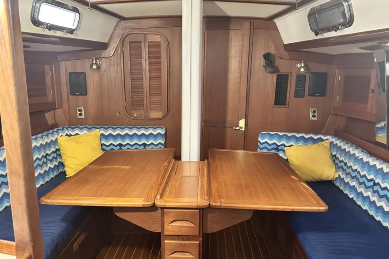 Bittersweet Yacht Photos Pics Interior of 1998 Tartan 4100 sailboat with wooden table and blue zigzag cushions.