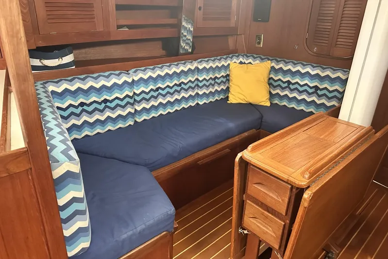 Bittersweet Yacht Photos Pics 1998 Tartan 4100 yacht interior with blue zigzag cushions and wooden cabinetry.