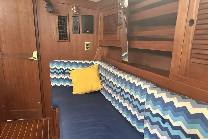 Bittersweet Yacht Photos Pics Cozy Tartan 4100 yacht interior with chevron-patterned cushions, wooden paneling, and a yellow pillow.