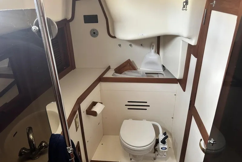 Bittersweet Yacht Photos Pics 1998 Tartan 4100 yacht bathroom with toilet, sink, and wooden accents.