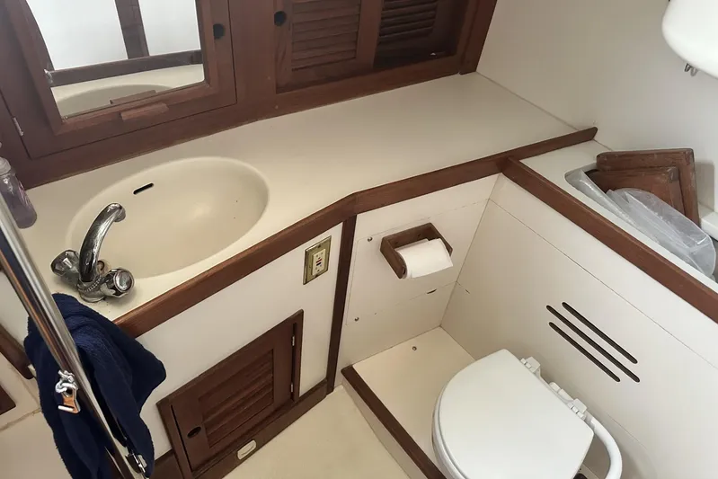 Bittersweet Yacht Photos Pics 1998 Tartan 4100 yacht bathroom with sink, toilet, and wooden accents.