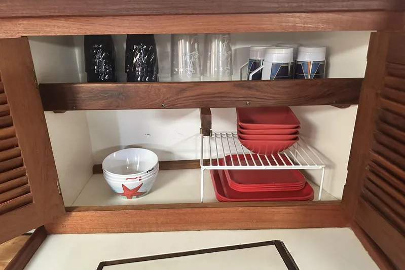 Bittersweet Yacht Photos Pics Cabinet interior with red dishes and cups in a 1998 Tartan 4100.
