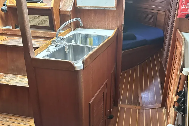 Bittersweet Yacht Photos Pics Interior of 1998 Tartan 4100 sailboat with wooden cabinetry and stainless steel sink.