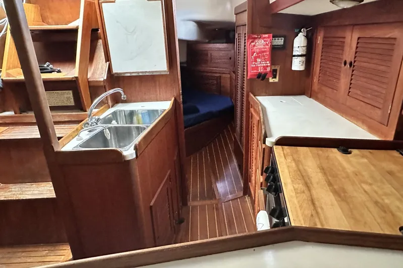 Bittersweet Yacht Photos Pics Interior of 1998 Tartan 4100 sailboat with wooden cabinetry and compact kitchen area.