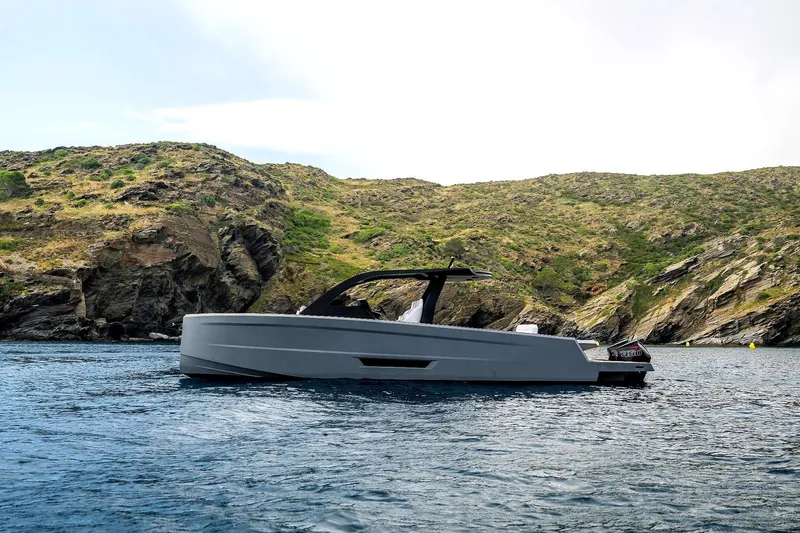 Maxim Yachts | Max43 Race Yacht Photos Pics 2026 Maxim Yachts 43 cruising near rocky coastline under clear sky.