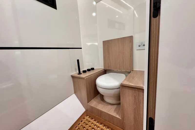 Maxim Yachts | Max43 Race Yacht Photos Pics Modern yacht bathroom with wooden accents, featuring a compact toilet. Maxim Yachts 43 Race, 2026 model.