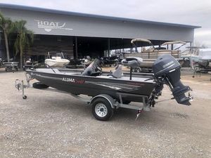 2019 Alumacraft Prowler 165 boat with Yamaha motor on trailer, parked outside a boat yard.