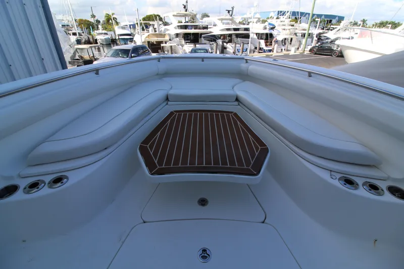 Better Than Most Yacht Photos Pics 2015 Boston Whaler 320 Outrage boat interior with cushioned seating and wooden table.