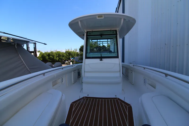 Better Than Most Yacht Photos Pics 2015 Boston Whaler 320 Outrage boat interior with seating and helm, docked outdoors.