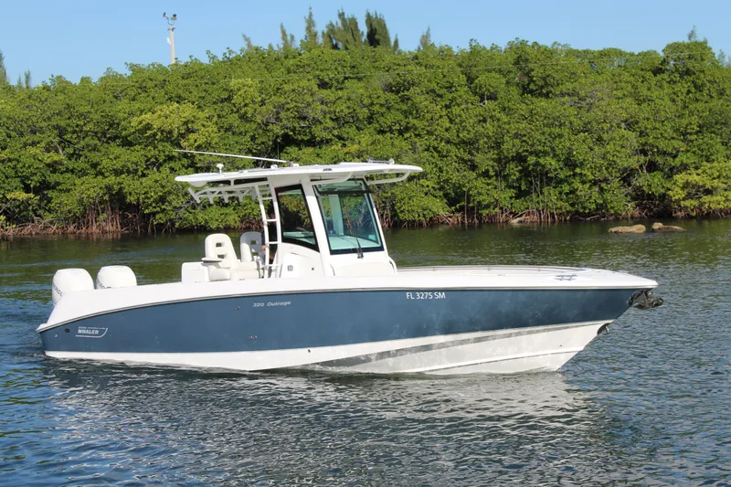 Better Than Most Yacht Photos Pics 2015 Boston Whaler 320 Outrage boat on calm water with lush green background.