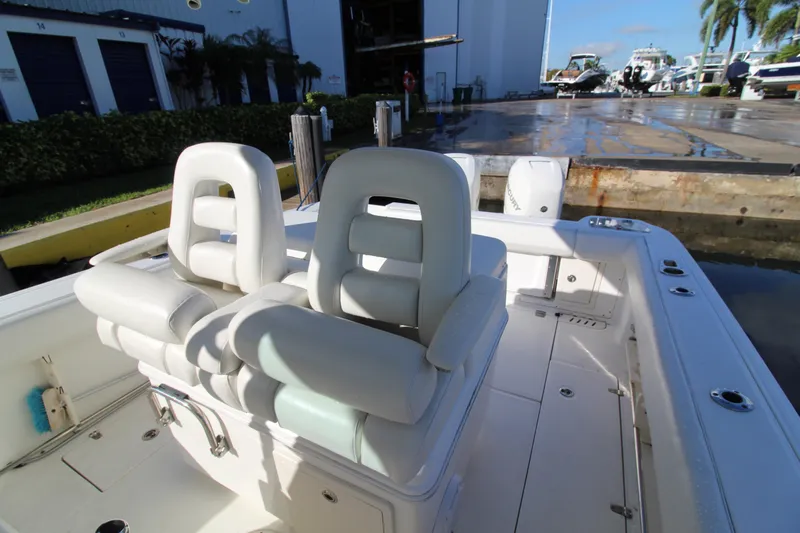 Better Than Most Yacht Photos Pics 2015 Boston Whaler 320 Outrage boat interior with white cushioned seating.