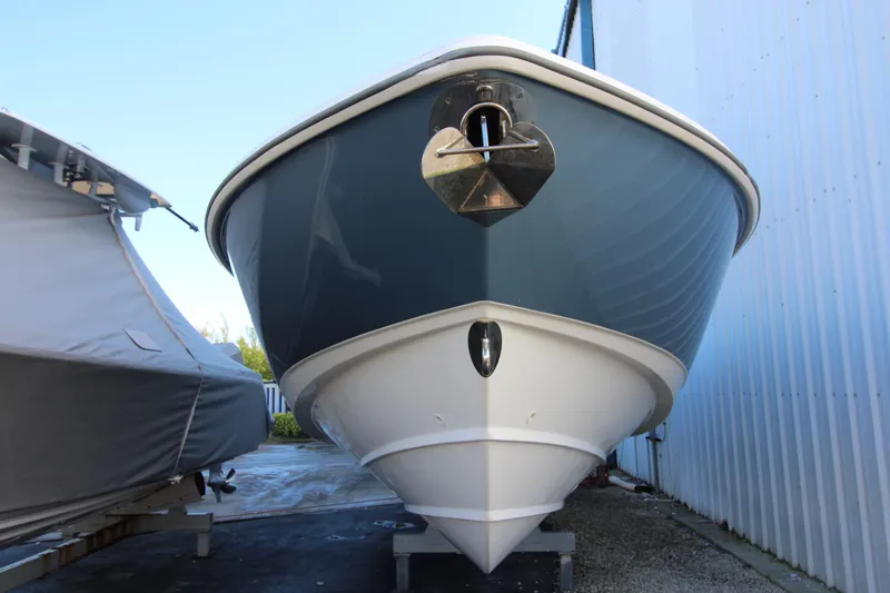 Better Than Most Yacht Photos Pics 2015 Boston Whaler 320 Outrage boat, front view, docked beside a covered vessel.