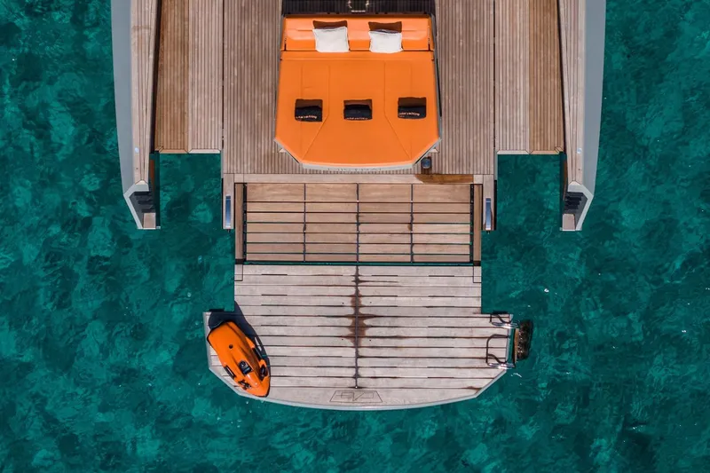 Mistral Yacht Photos Pics Aerial view of 2023 Evo Yachts R4 XT with orange sunbed and water scooter on turquoise sea.