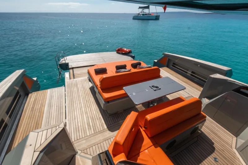 Mistral Yacht Photos Pics Luxurious 2023 Evo Yachts R4 XT with orange seating, overlooking serene turquoise waters.