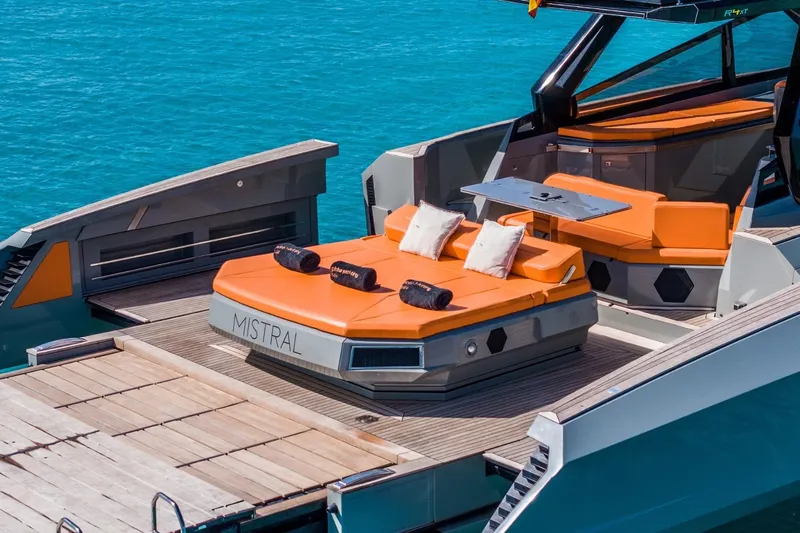Mistral Yacht Photos Pics 2023 Evo Yachts R4 XT luxury yacht with orange seating, docked on turquoise water.