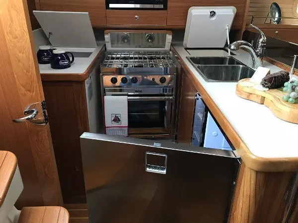 Aolani II Yacht Photos Pics Compact kitchen in 2018 Catalina 425 yacht with stove, sink, and fridge.