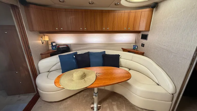  Yacht Photos Pics 2003 Regal Commodore 4260 yacht interior with curved seating, wooden table, and cushions.