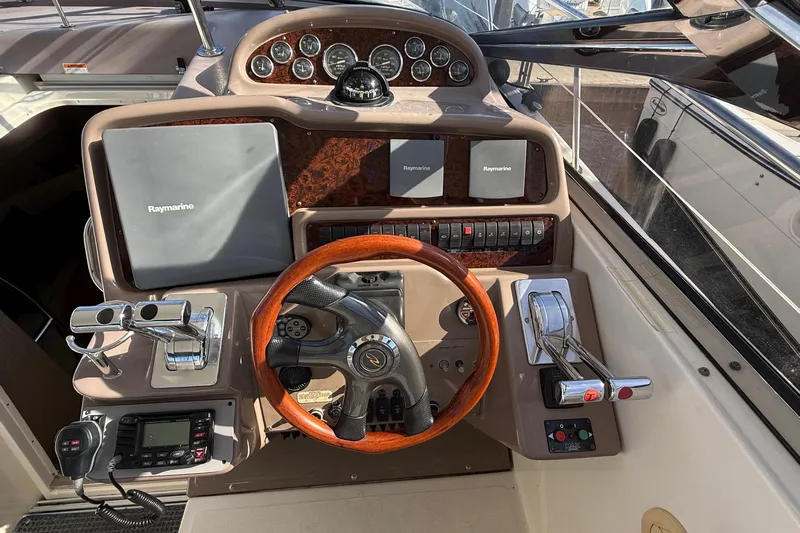  Yacht Photos Pics 2003 Regal Commodore 4260 helm with Raymarine navigation and wooden steering wheel.