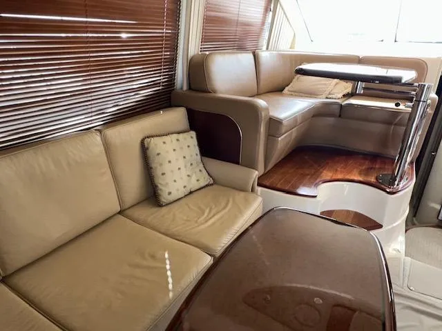  Yacht Photos Pics Luxurious interior of 2006 Sea Ray 44 Sedan Bridge with leather seating and wooden accents.