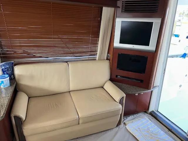  Yacht Photos Pics Interior of 2006 Sea Ray 44 Sedan Bridge with beige sofa and wall-mounted TV.