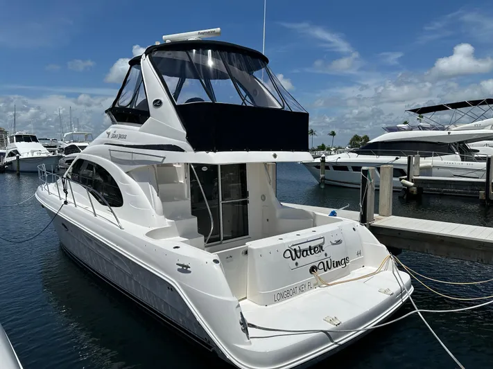 Yacht Photos Pics 2006 Sea Ray 44 Sedan Bridge yacht docked at marina under clear blue sky.