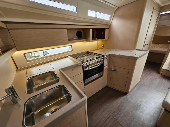  Yacht Photos Pics 2024 Beneteau Oceanis 40.1 yacht interior kitchen with modern appliances and wood finish.