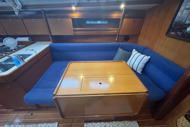 Falcon Yacht Photos Pics Interior of 2004 Dufour 40 Performance yacht with blue seating and wooden table.