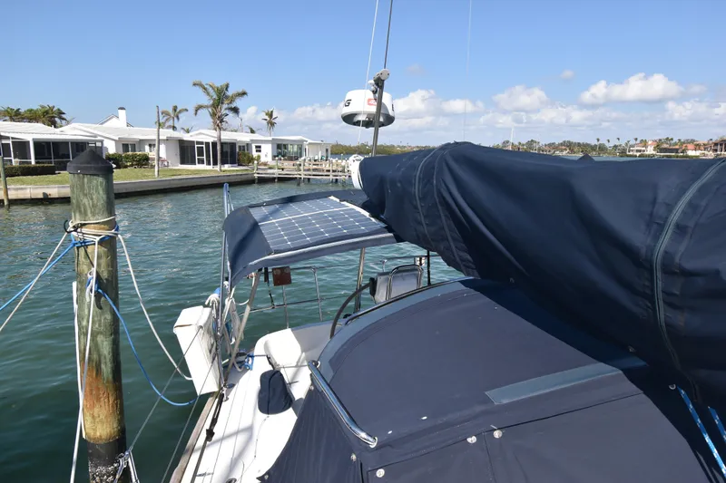 Zia Yacht Photos Pics 2004 Sabre 386 sailboat docked, featuring solar panels and blue canvas cover.