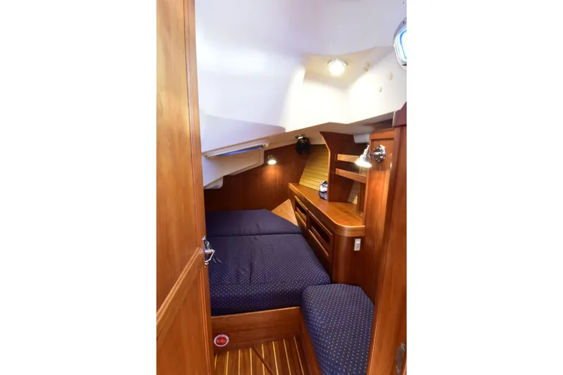 Zia Yacht Photos Pics Cozy cabin interior of 2004 Sabre 386 sailboat with wooden furnishings and blue bedding.