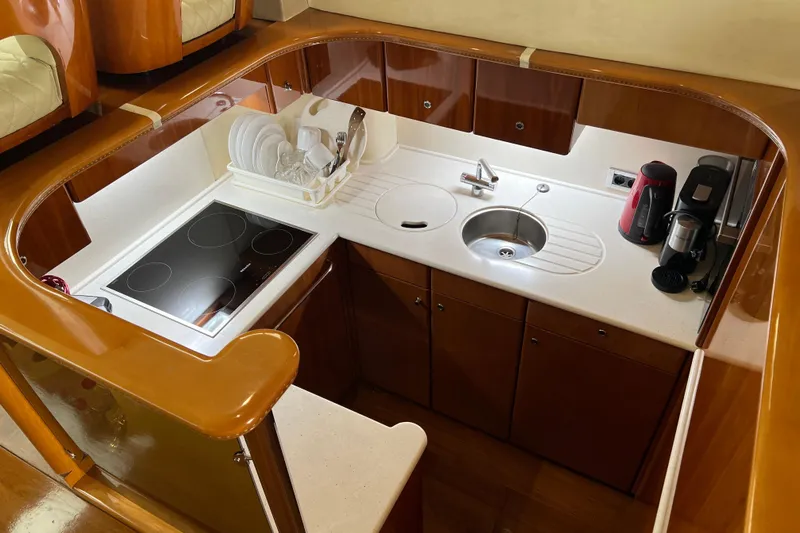  Yacht Photos Pics Luxurious kitchen in 2001 Princess 56 yacht with modern appliances and elegant wood finish.