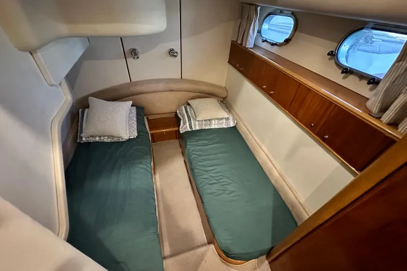  Yacht Photos Pics Twin cabin interior of 2001 Princess 56 yacht with portholes and wooden cabinetry.